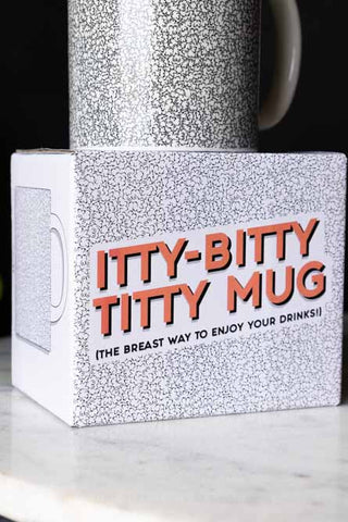 The box of The Itty Bitty Titty Mug, with the mug on top.