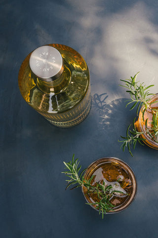 The Paveau - Gorgeous Ribbed Glass Carafe in Amber seen from above, styled on a table with two drinks.