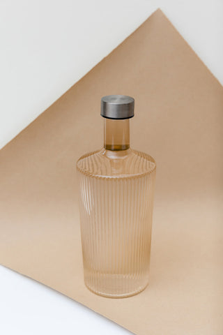 The Paveau - Gorgeous Ribbed Glass Carafe in Amber styled on matching background.