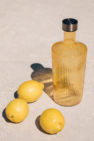 The Paveau - Gorgeous Ribbed Glass Carafe in Amber styled with three lemons.