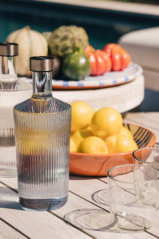 The Paveau - Gorgeous Ribbed Glass Carafe in Grey Blue styled on an outdoor tablescape.