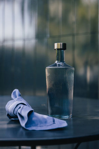 The Paveau - Gorgeous Ribbed Glass Carafe in Grey Blue styled with a napkin.