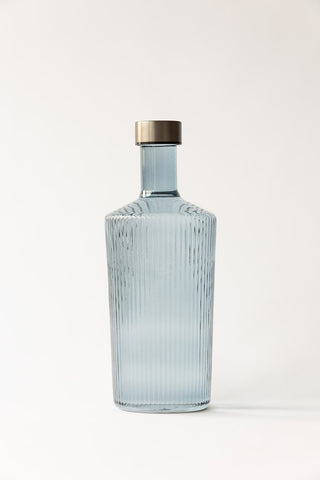 The Paveau - Gorgeous Ribbed Glass Carafe in Grey Blue on a plain background.