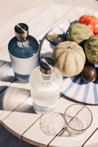 The Paveau - Gorgeous Ribbed Glass Carafe in White styled on an outdoor table.