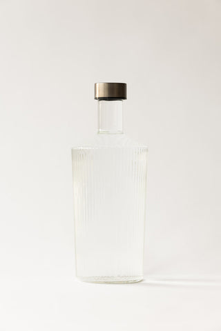 The Paveau - Gorgeous Ribbed Glass Carafe in White in front of a plain background.