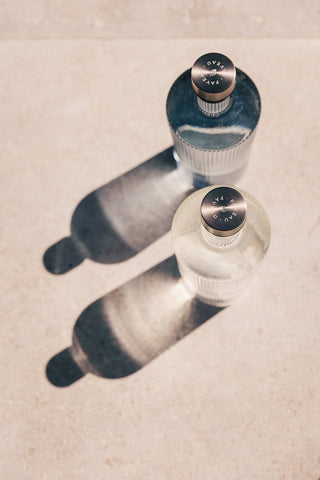 The Paveau - Gorgeous Ribbed Glass Carafe in White styled with a blue version in the sunshine.