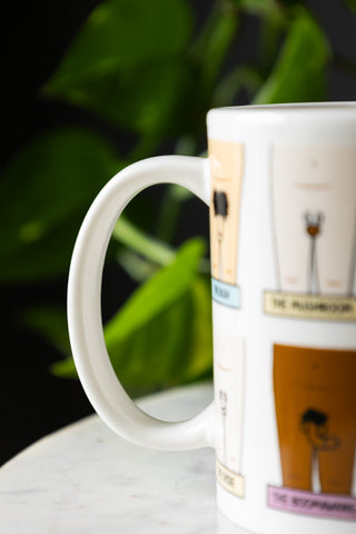 Detail shot of the handle of The Penis Mug, with a plant in the background.