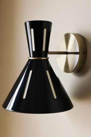 Lifestyle image of the Tribeca Metal Wall Light illuminated and displayed on a light wall