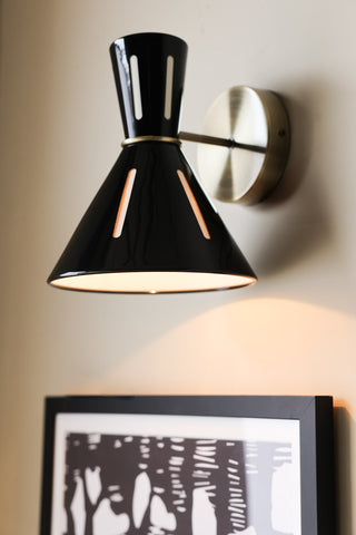 Lifestyle image of the Tribeca Metal Wall Light illuminated and displayed on a lounge wall