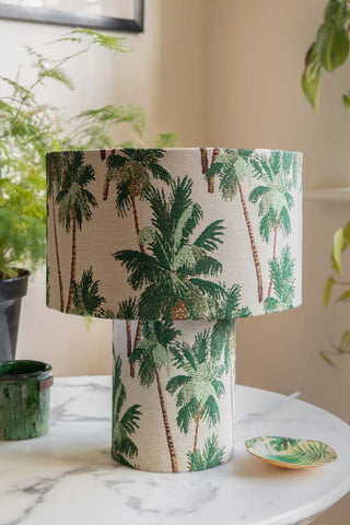 Beautiful fabric table lamp with green palm trees printed over the base and shade.