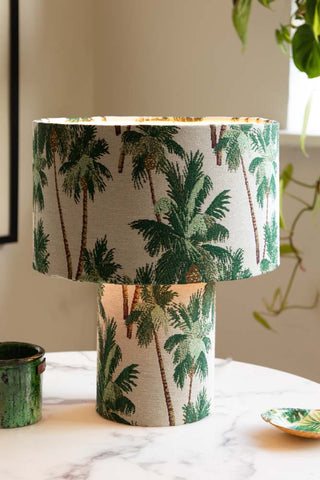 A green fabric table lamp on a side table.