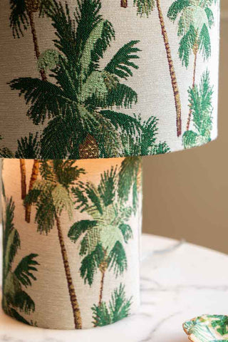 A stunning all-fabric table lamp with green palm trees printed on repeat on the shade and base.