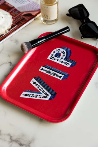 The VIP Red Tray styled with a makeup brush, sunglasses, perfume and a magazine.