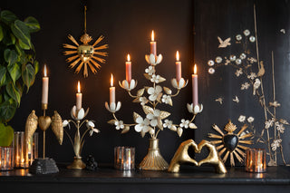 A beautiful collection of loved themed products in gold, white and black. In the centre is a flower candelabra with pink candles. 