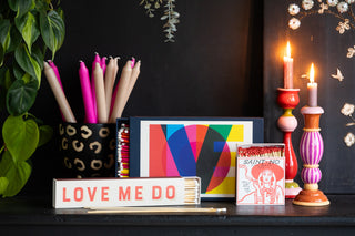 A colourful collection of matches and candlesticks in red, pink and white.