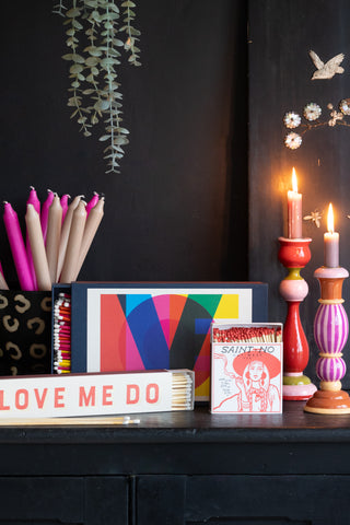 A colourful collection of candlesticks, candles and matches.