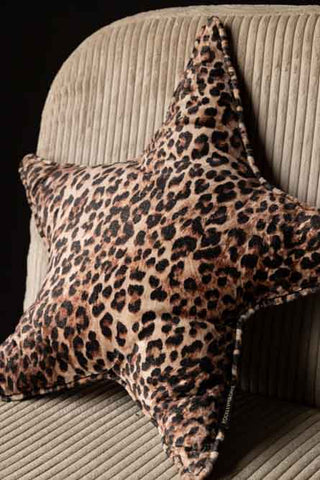 Close-up of the Velvet Star Cushion In Leopard Print displayed on a chair.