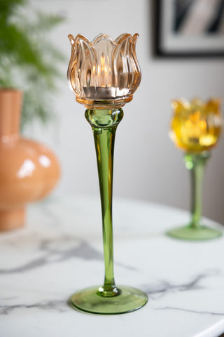 The Vintage-Style Orange Glass Flower Candle Holder styled on a white marble table.