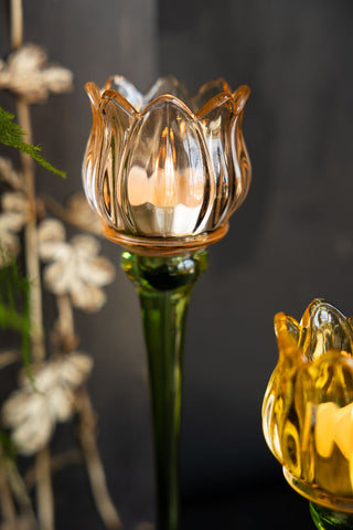 Close-up of the Vintage-Style Orange Glass Flower Candle Holder in front of a dark background.