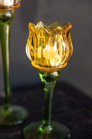 Close-up of the Vintage-Style Yellow Glass Flower Candle Holder in front of a black background.