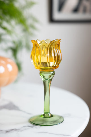 The Vintage-Style Yellow Glass Flower Candle Holder styled on a white table.