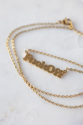 The Waterproof Fuck Off Gold Necklace displayed on a white surface.