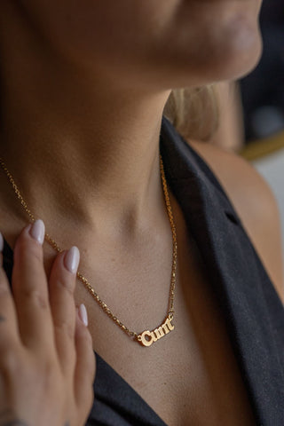 The Waterproof Gold Cunt Necklace styled on a model.