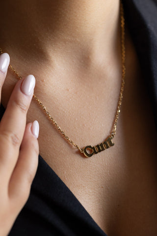 Close-up of the Waterproof Gold Cunt Necklace styled on a model.