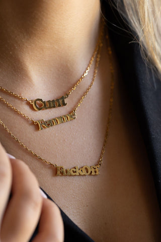 The Waterproof Gold Femme Necklace layered with others, styled on a model.