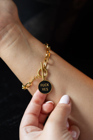 The Waterproof Gold Fuck Yes Charm Bracelet modelled on a wrist.