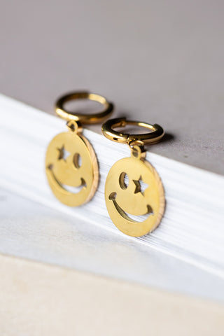 The Waterproof Gold Wink Face Charm Earrings displayed togther.