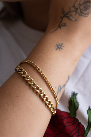 The Waterproof Wink Face Gold Chain Bracelet on a model's wrist showing the two chains.