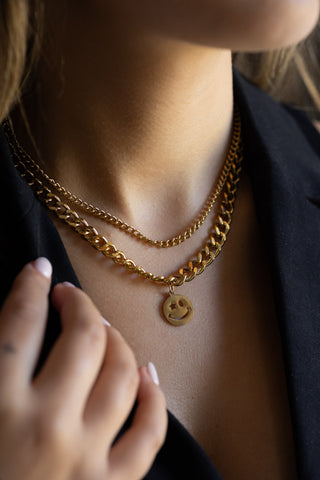 The Waterproof Wink Face Gold Duo-Chain Necklace being worn by a model.