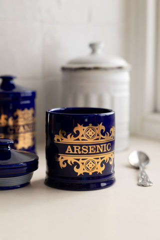 The What's Your Poison - Arsenic Jar shown with it's lid off in front of a white kitchen container.