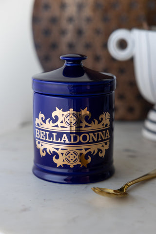 The What's Your Poison - Belladonna Jar displayed on a marble counter with a spoon.