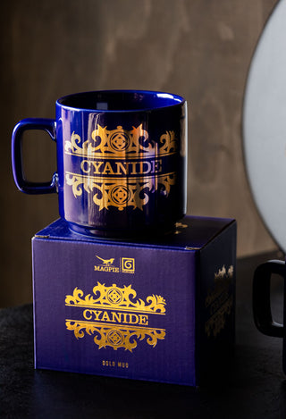 The What's Your Poison - Cyanide Mug displayed on top of its box on a table.