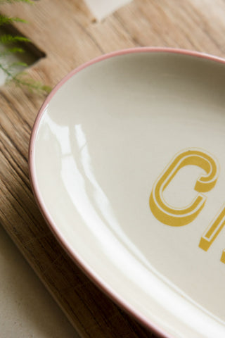 Detail shot of the White Ciao Plate styled on a wooden serving board.