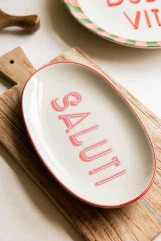 The White Saluti Plate styled on a wooden serving board with other serveware in the background.