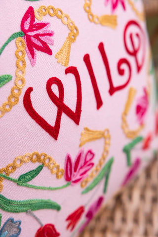 Close-up of the 'Wild' text and floral design on the Wild Embroidered Cushion.