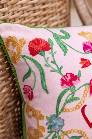 Detail shot of the floral design on the corner of the Wild Embroidered Cushion.