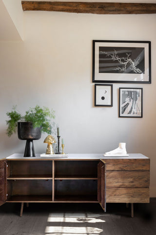 The Wood & Marble Barcelona Sideboard with the doors open, styled with various accessories on and some art prints on the wall above.