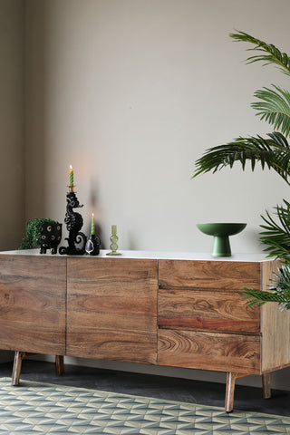 The Wood & Marble Barcelona Sideboard styled with lit candles, plants  and a green display bowl.