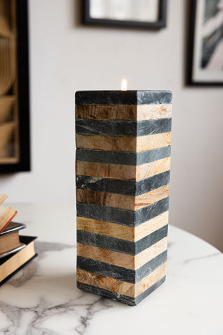 The Wood & Slate Tealight Holder with a lit tealight inside, styled on a white marble table with some books.