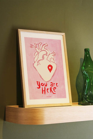 The You Are Here Art Print styled in a frame on a shelf, leaning against the wall.