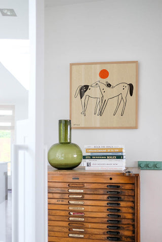 The You & Me Art Print in a square freame over some chest of drawers.