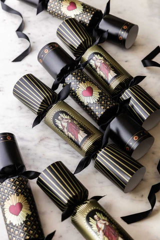 The Set Of 6 You've Got To Have Faith Christmas Crackers styled together on a white surface with some black ribbon.