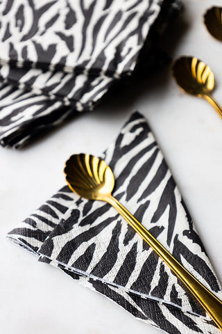 The Zebra Print Napkins - Pack Of 20 with some gold spoons.