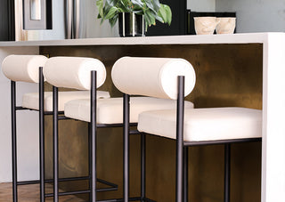 Three of the Cream & Black Faux Leather Roll Back Bar Stools under a kitchen breakfast bar.
