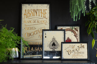 Landscape image with a dark background and in the centre four vintage style mirrors. The largest mirror is on the left and features vintage writing. In the centre is a playing card mirror and to the right is a open for business typography mirror.