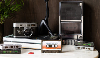 Various retro storage tins styled together with some books and a plant on a marble surface.